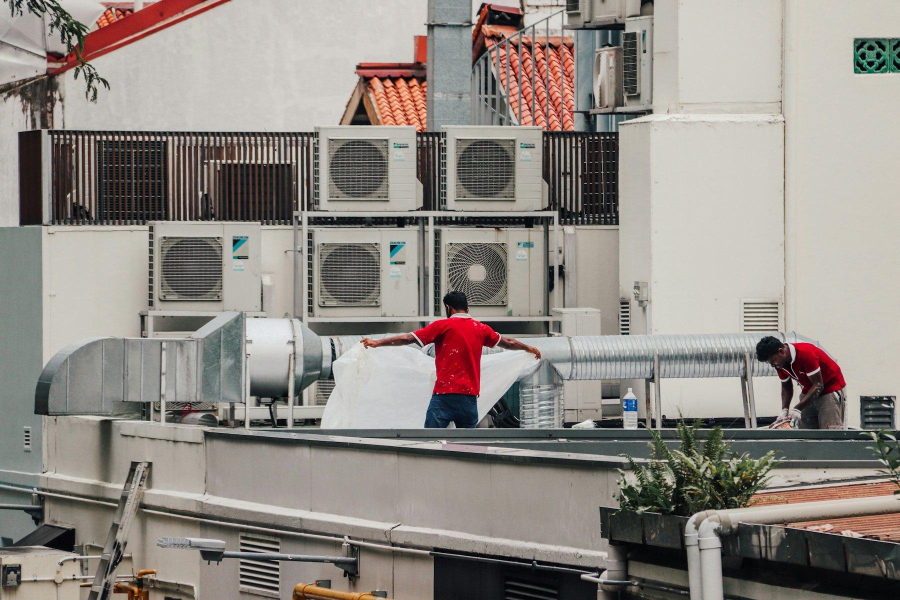 Technicians servicing rooftop air-conditioning units