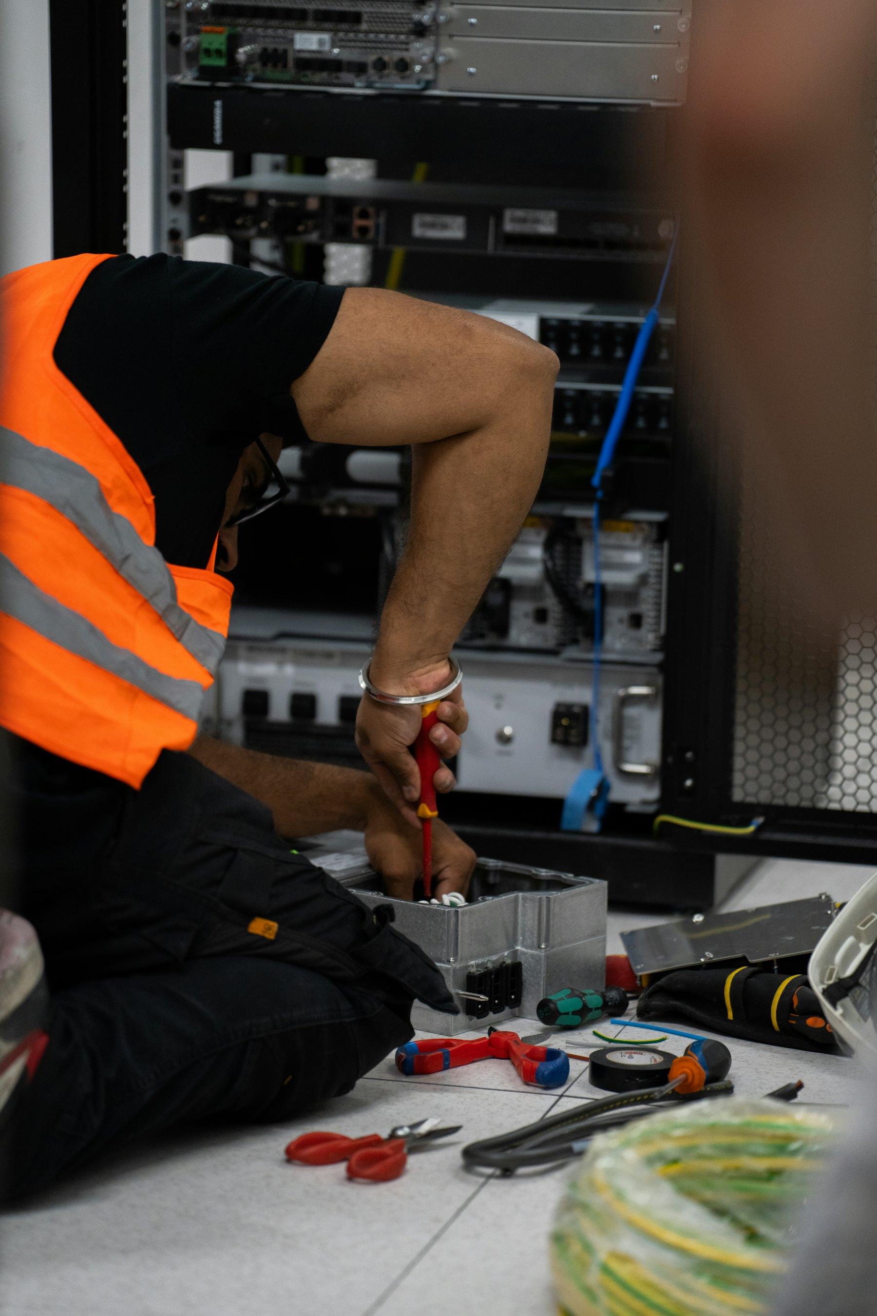 Technician working on network equipment in a rack