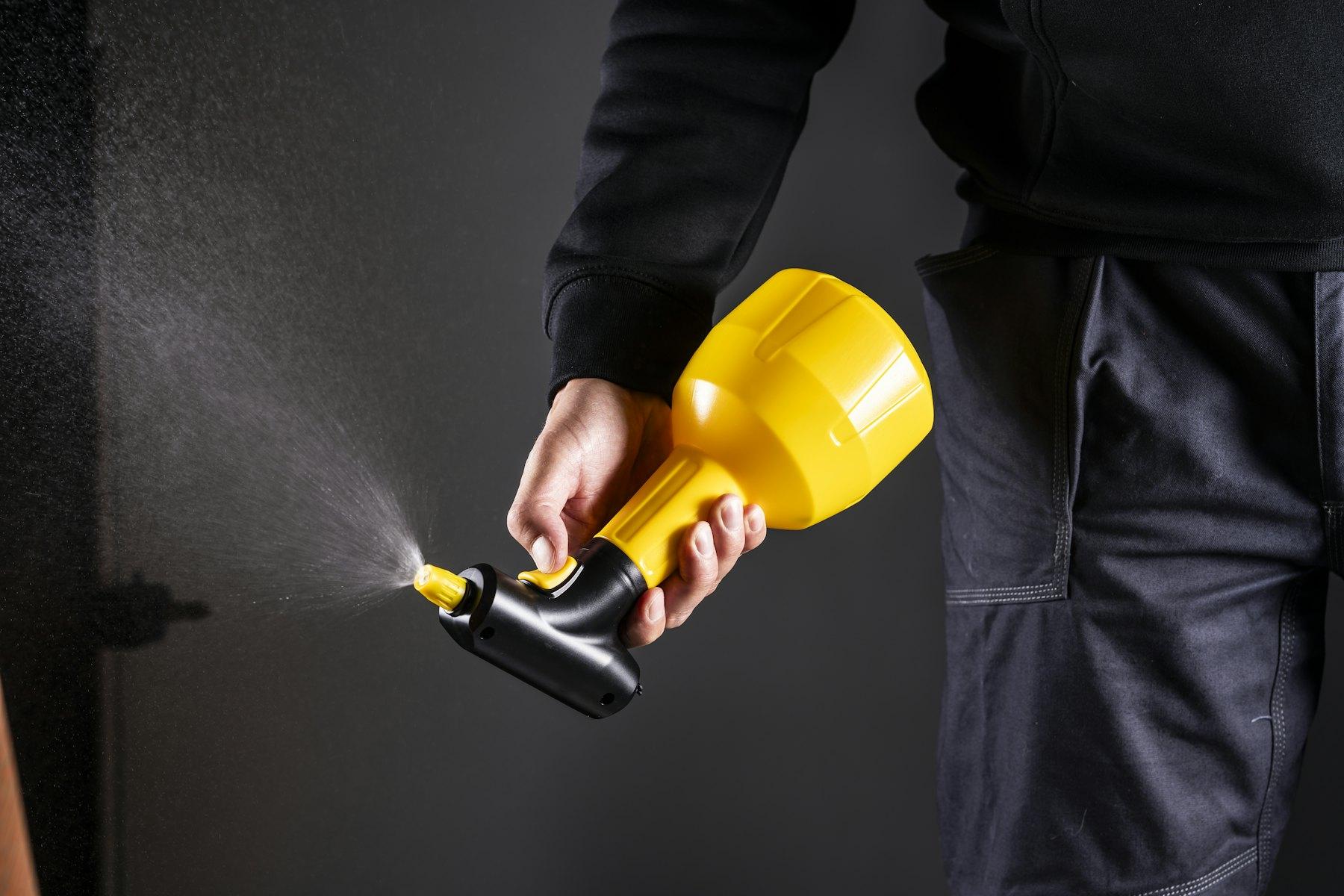 Technician using a handheld pressure sprayer